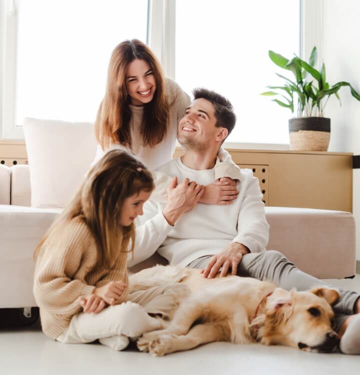 Family and dog sitting on carpet