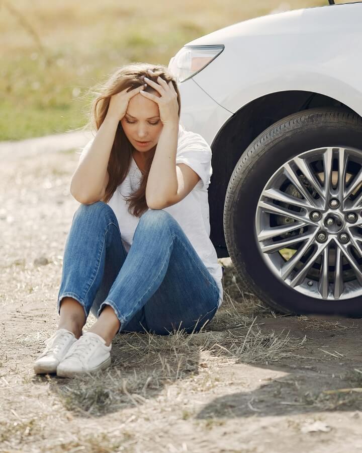 Woman with hands on head after car accident
