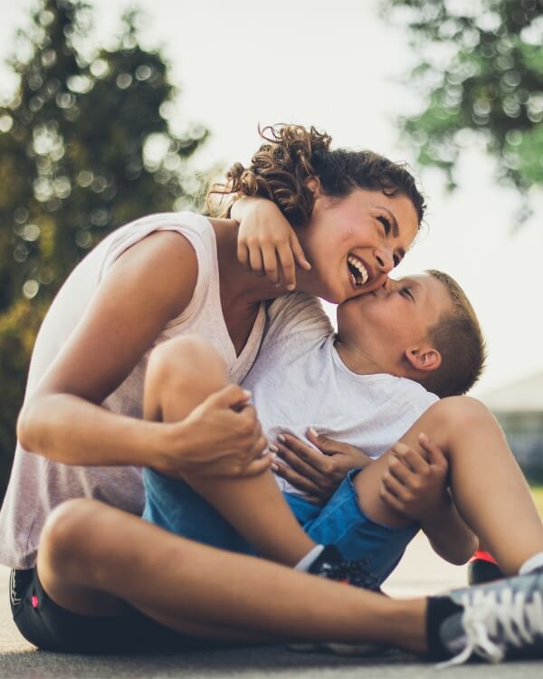 Young boy kissing his mom on the cheek