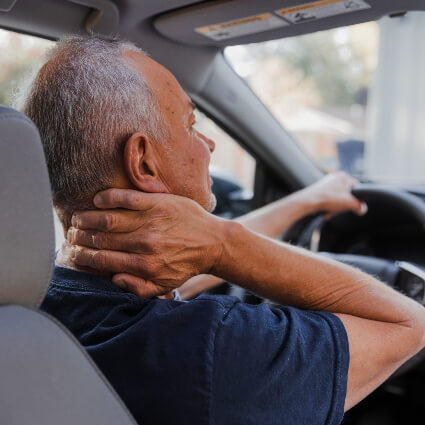 Man with neck pain sitting in car