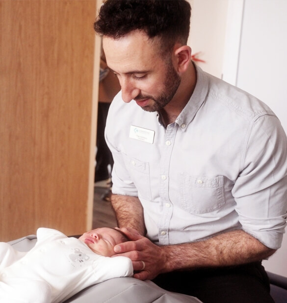 Eastbourne chiropractor Theo Kyriacou adjusting a baby