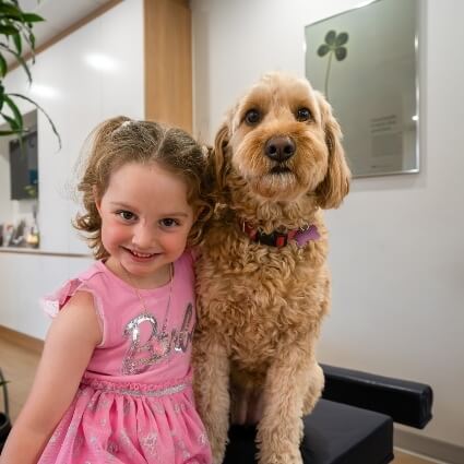 kid smiling with our office dog