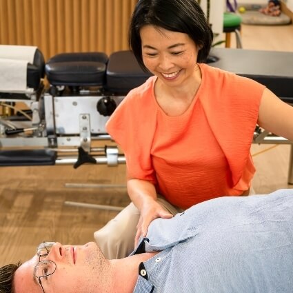 Dr Irene adjusting practice member who is laying down