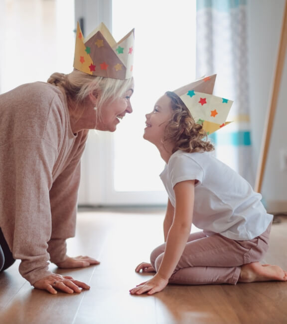 Mom and kid playing with paper crowns on