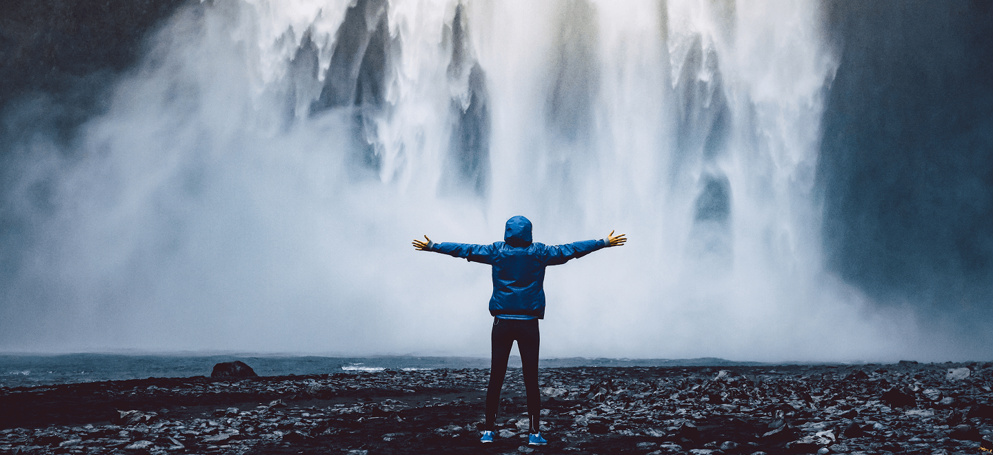 Man standing in front of water falls
