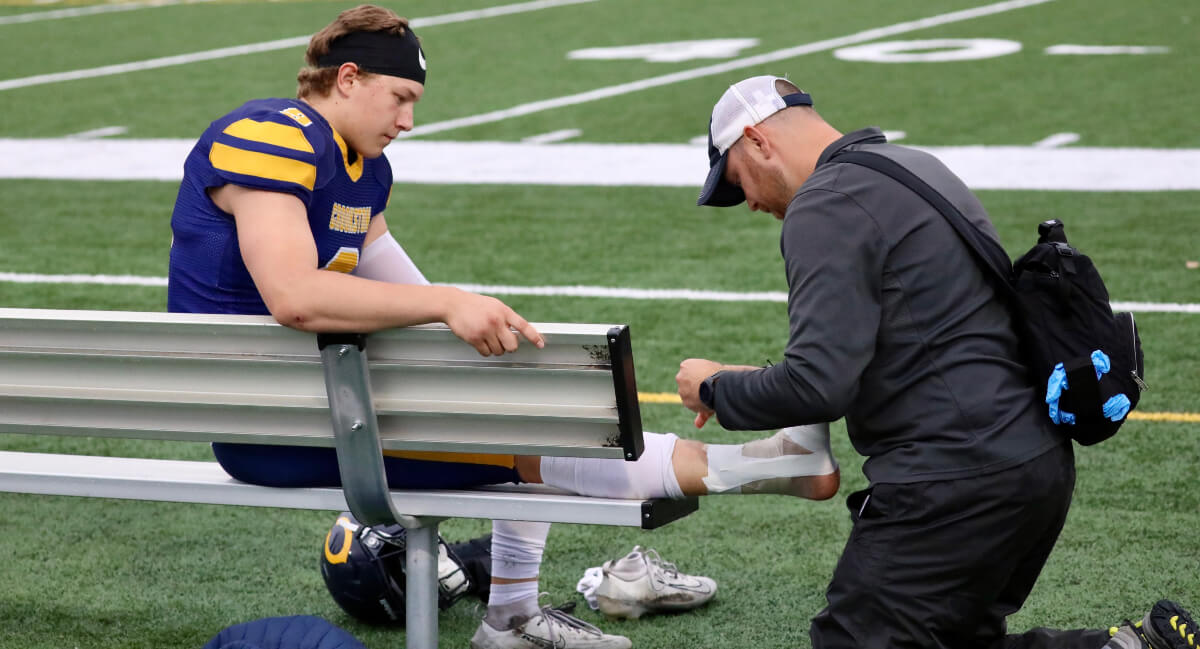 Chiropractor assisting Crookston athlete with injury