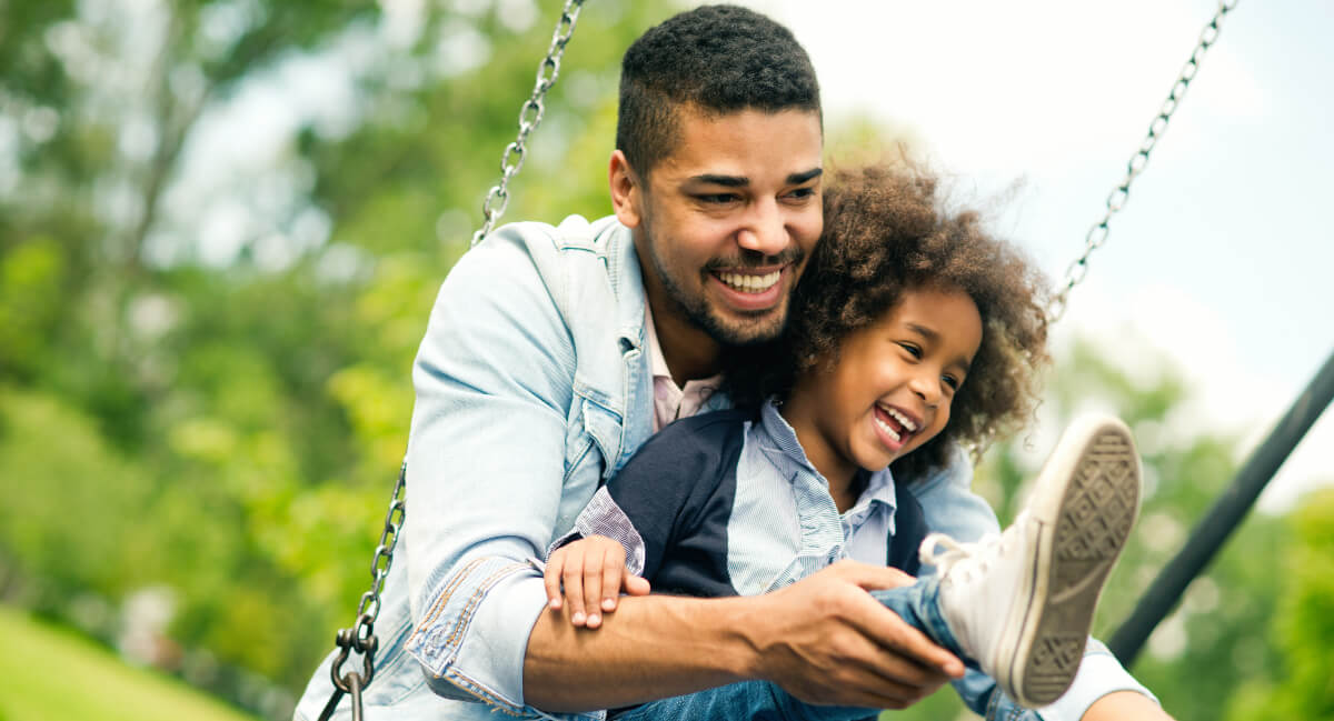 Dad and young daughter on swing