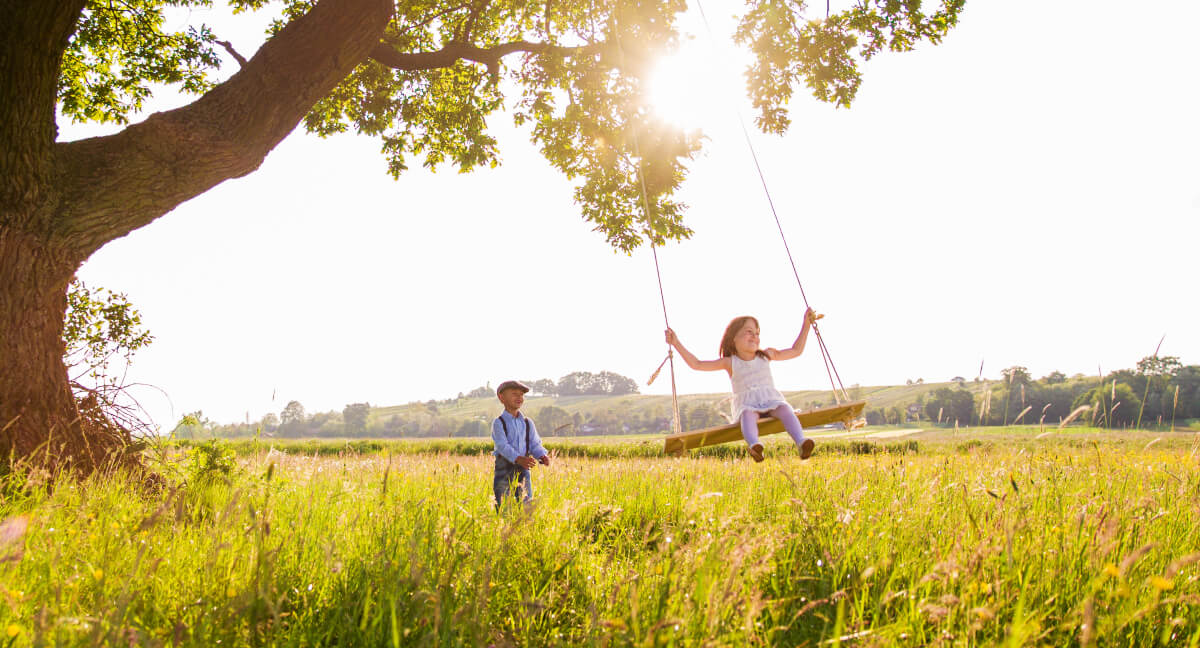 Boy and girl playing on swing