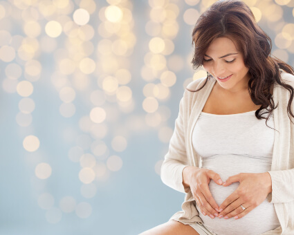Pregnant Woman making heart shape with hands on  her stomach
