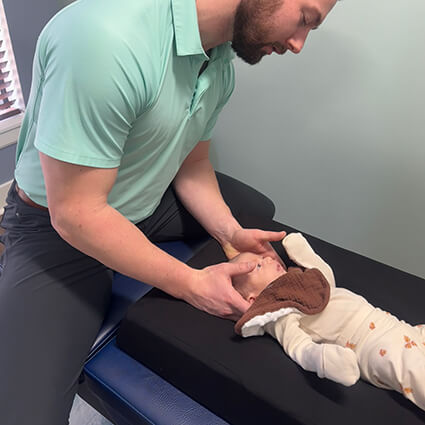 Dr. Noah adjusting newborn