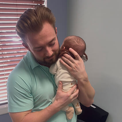 Dr. Noah holding newborn baby