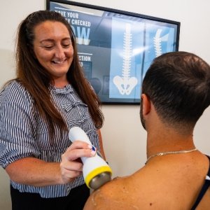 Dr Kristina using softwave tool on patients shoulder