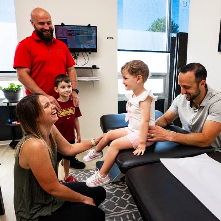 Family smiling during child's chiropractic adjustment