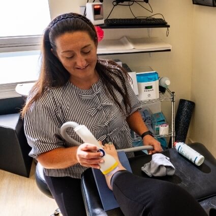 Dr Kristina using softwave tool on patients ankle