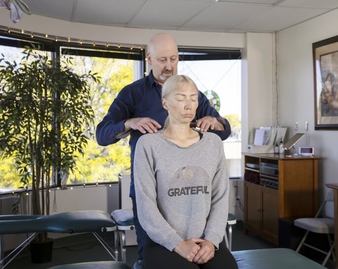 Lakewood chiropractor Dr Rick adjusting patients shoulders