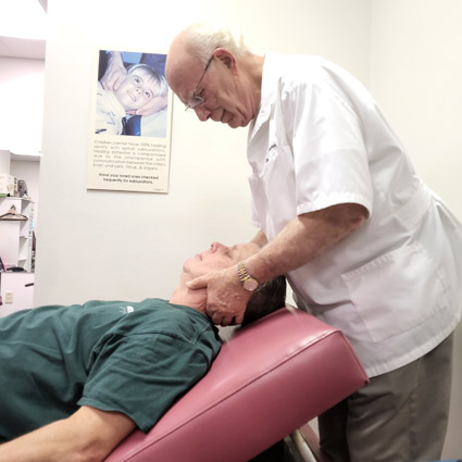 Dr. Wolverton gently adjusting a patient's neck.