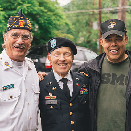 three veterans smiling together