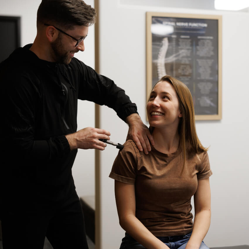 Dr Levi adjusting patients shoulder with tool