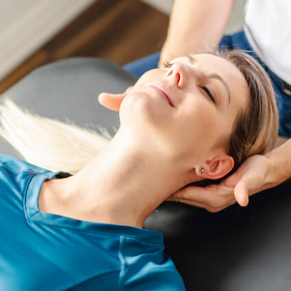 smiling person having neck adjusted