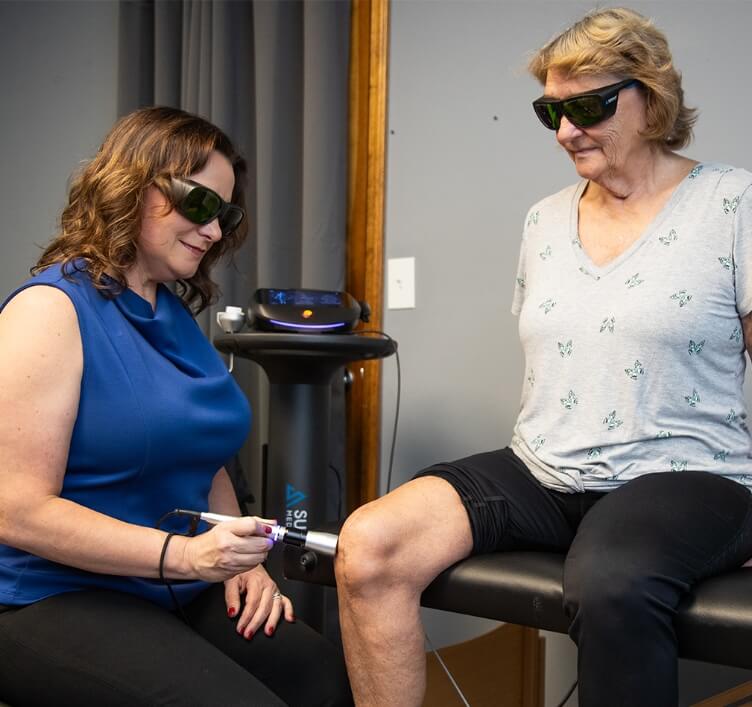 Granite City chiropractor Dr Darin using laser tool on patients knee