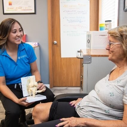 practitioner showing patient knee bones