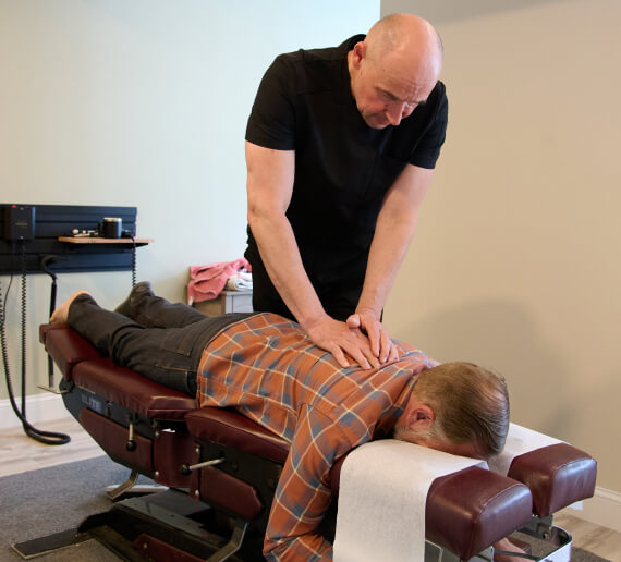 Stratham chiropractor Dr Bart adjusting patient on adjusting table