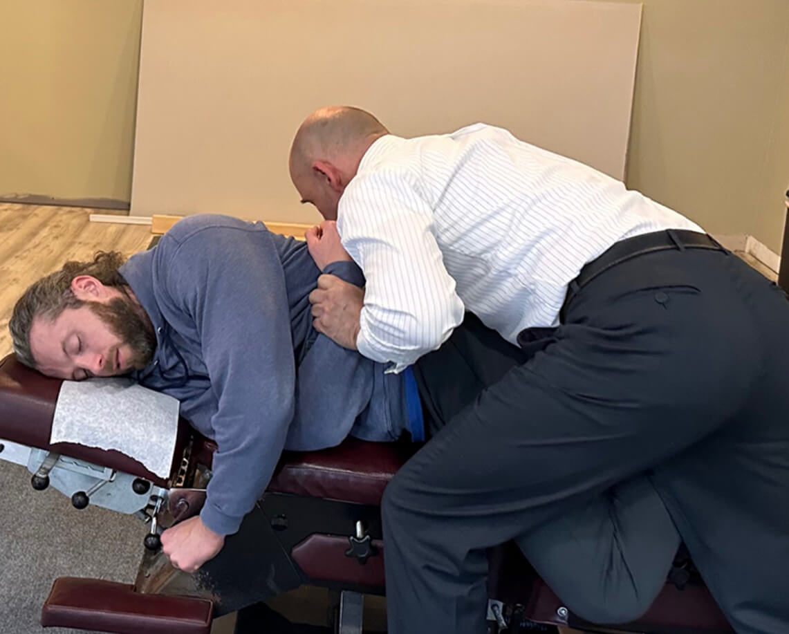 Stratham chiropractor Dr Bart adjusting patients mid back
