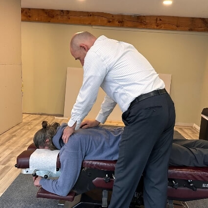 Stratham chiropractor Dr Bart adusting patients back