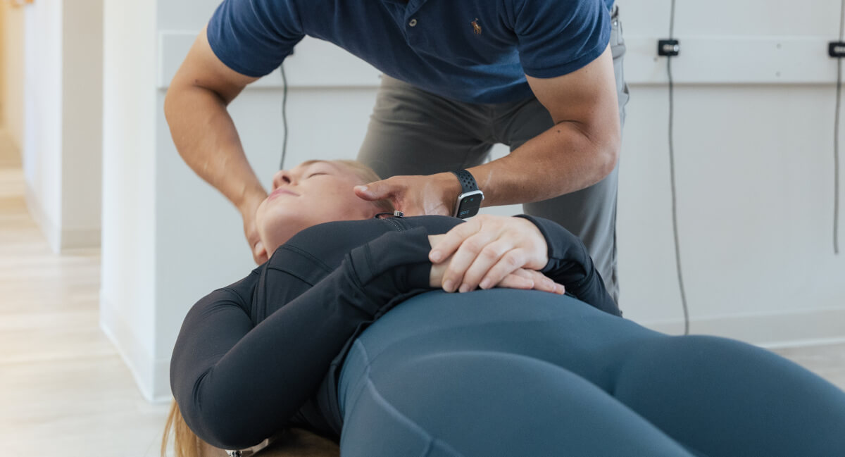 Male Naprapathic Medicine practitioner adjusting patient's neck