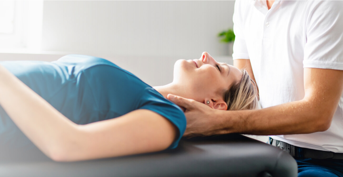 woman laying on table having neck adjusted