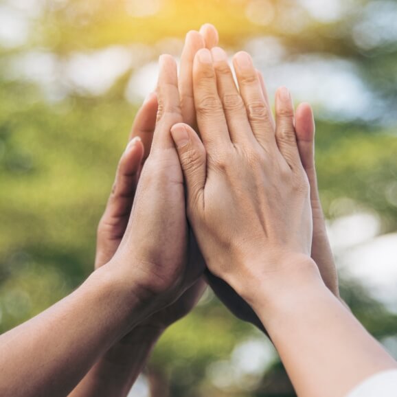 multiple people high fiving in the air