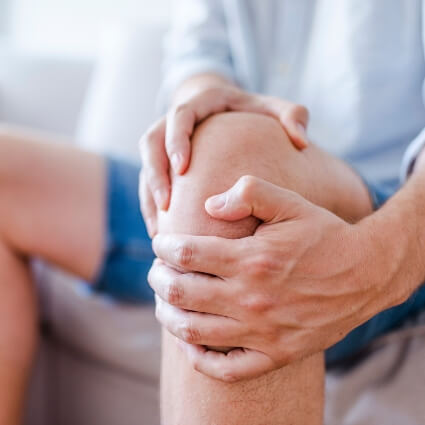 man holding his knee in pain