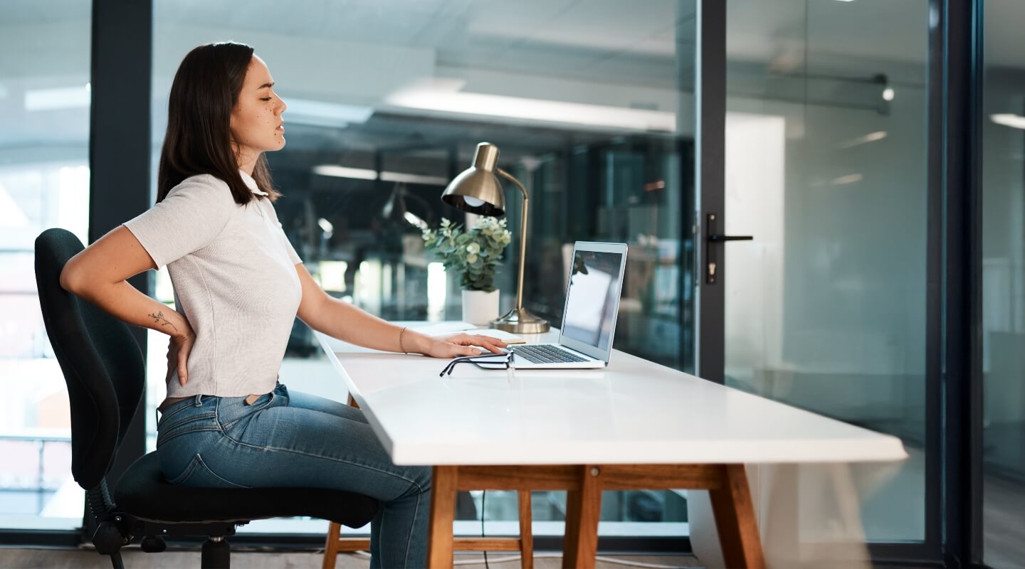 Woman with back pain sitting at desk