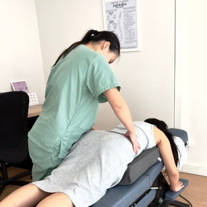 Dr Minji adjusting pregnant patients back