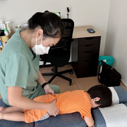 Dr Minji adjusting childs back