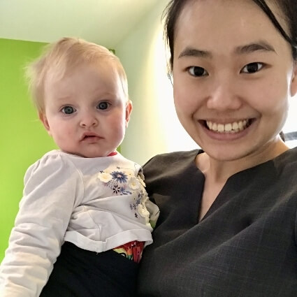 Dr Minji smiling with a baby