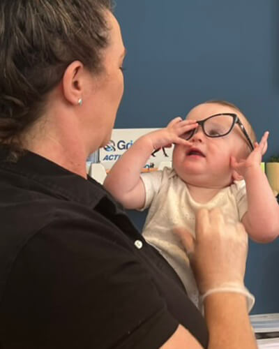 baby holding glasses