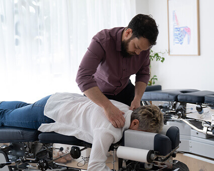 Dr. Luke adjusting woman's shoulder