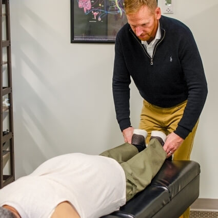 Dr John adjusting patients legs