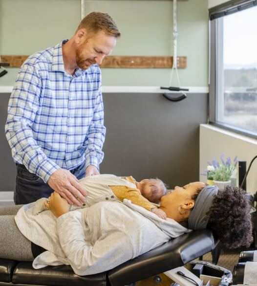 Central Park chiropractor Dr Steffens adjusting baby who is laying on mom