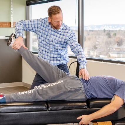 man having leg adjusted by Central Park chiropractor Dr John