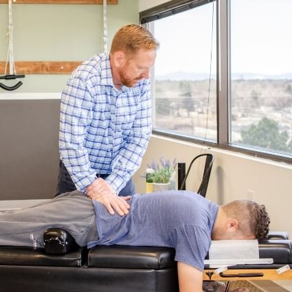 Dr John adjusting patients lower back
