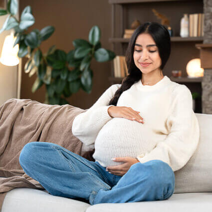 woman smiling cradling pregnant stomach