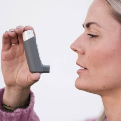Woman holding an asthma inhaler