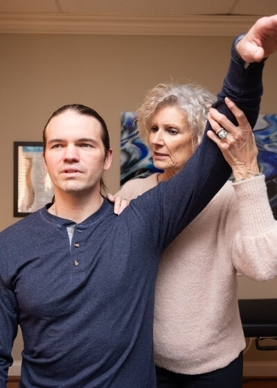 Huntersville chirorpactor Dr Ginni checking patients shoulder