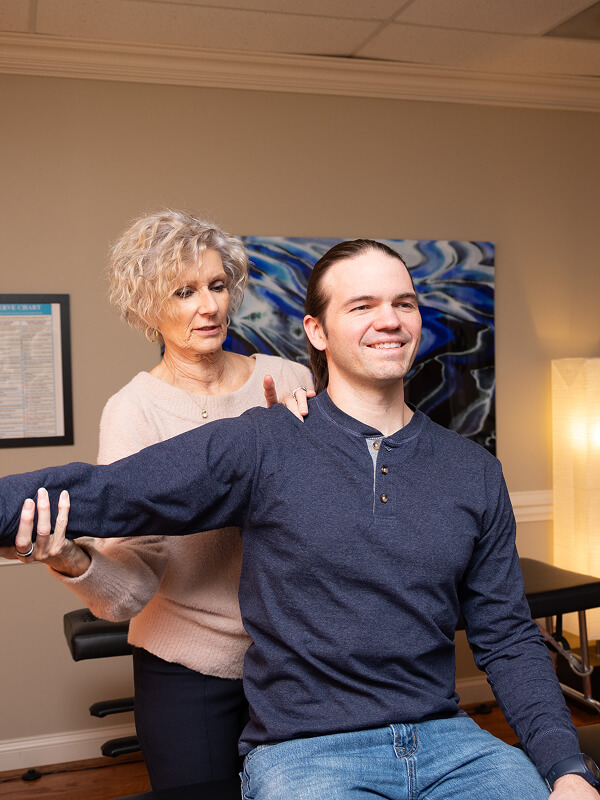 Huntersville chiropractor Dr Ginni examining patients arm
