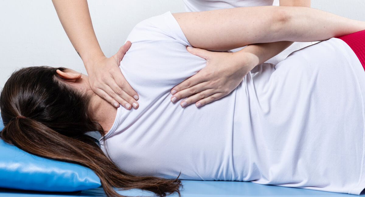 Female patient receiving an upper-back-adjustment