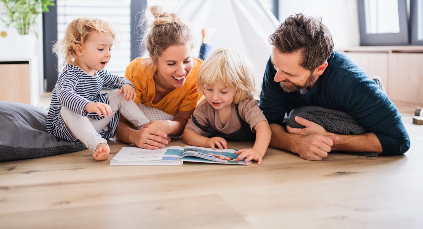 Family of four reading a book