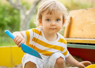 boy-in-striped-shirt-playing-in-sandbox-sq
