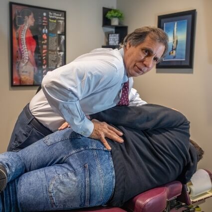 Dr Gavric adjusting patients back who is laying down